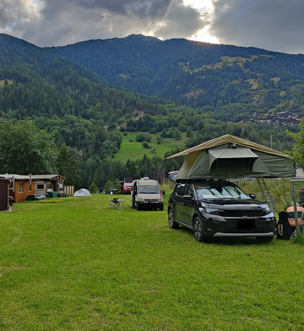 Van avec tente de toit au camping